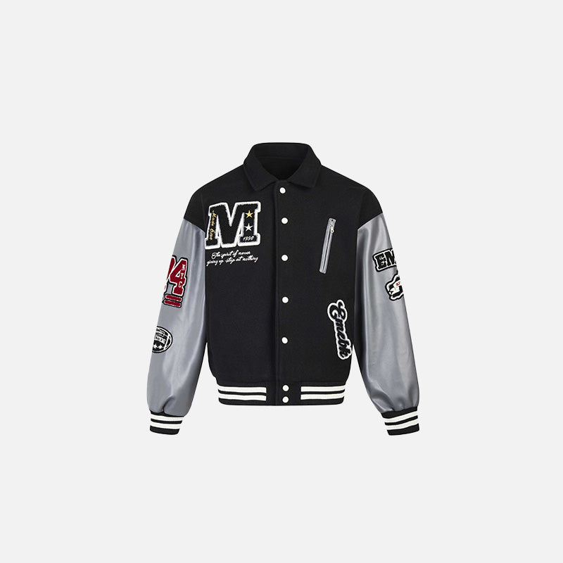 Front view of the black Patchwork Varsity Jacket in a gray background