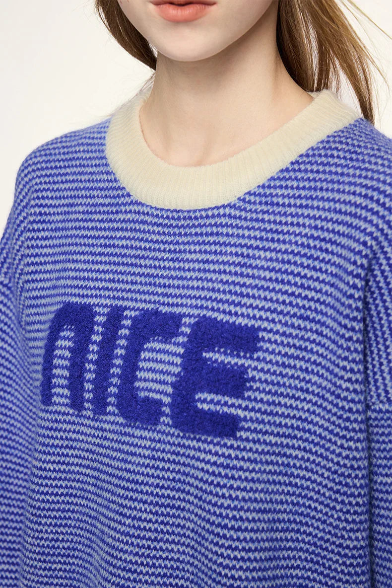 Model wearing the blue NICE Slogan Sweater
